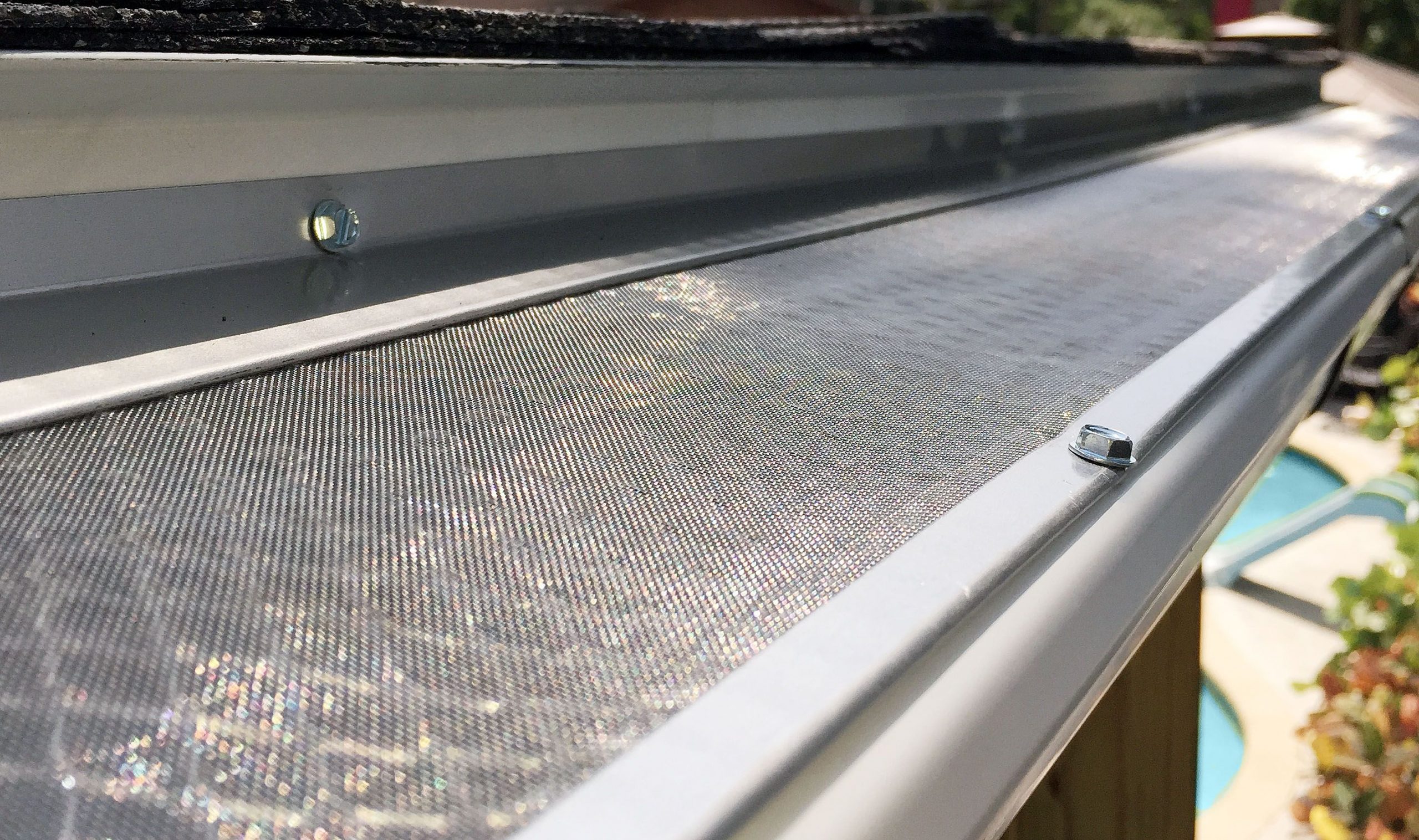 Close-up of a window insect screen with a blurred outdoor view.